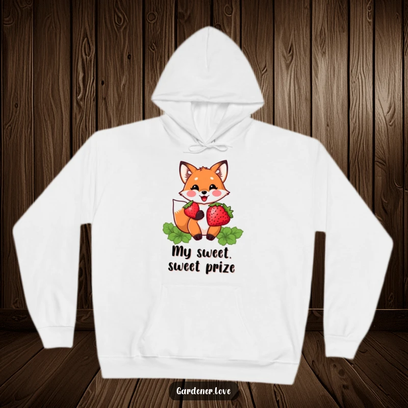 Funny hoodie featuring a delighted Kawaii fox character proudly holding a plump strawberry, exuding warmth and sweetness.